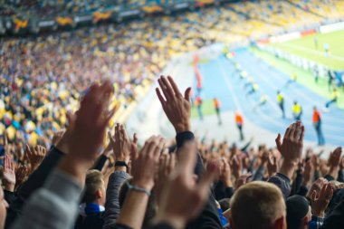 Futbol-futbol taraftarları takımlarını destekliyor ve tam stadyumda golü açık havada kutluyorlar.