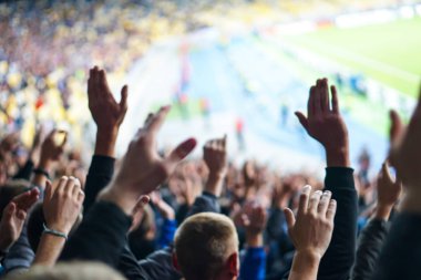 Futbol-futbol taraftarları takımlarını destekliyor ve tam stadyumda golü açık havada kutluyorlar.