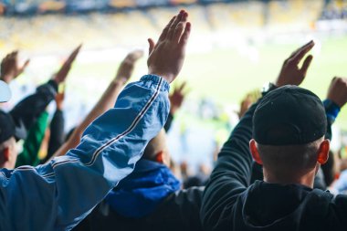 Futbol-futbol taraftarları takımlarını destekliyor ve tam stadyumda golü açık havada kutluyorlar.