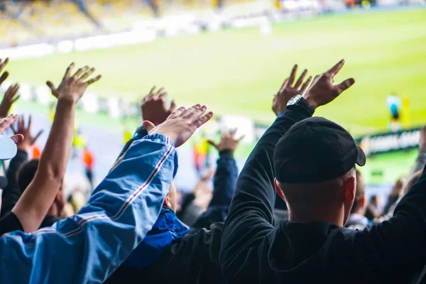 Football- soccer fans support their team and celebrate goal in full stadium with open air.