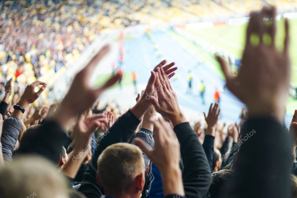 Football- soccer fans support their team and celebrate goal in full stadium with open air.