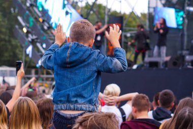 Çocuklar bir sokak konserinde boynuna dolanıyor