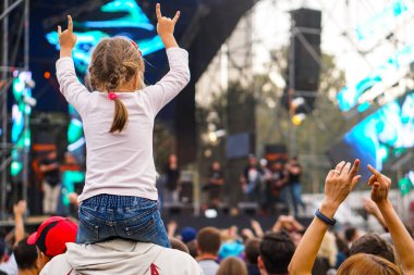 Çocuklar bir sokak konserinde boynuna dolanıyor