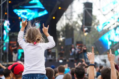 Çocuklar bir sokak konserinde boynuna dolanıyor