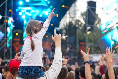 Çocuklar bir sokak konserinde boynuna dolanıyor