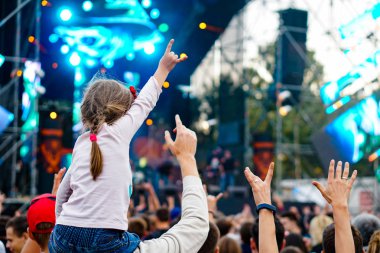 Çocuklar bir sokak konserinde boynuna dolanıyor