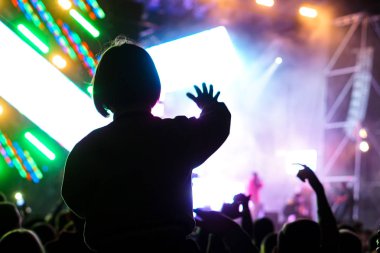 Çocuklar bir sokak konserinde boynuna dolanıyor