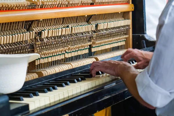 Street musician playing the old shabby piano. — Stock Photo, Image