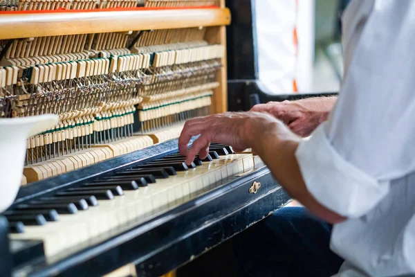 Street musician playing the old shabby piano. — Stock Photo, Image