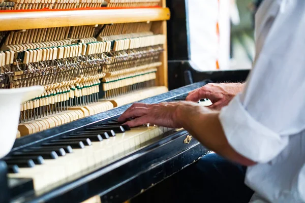 Street musician playing the old shabby piano. — Stock Photo, Image