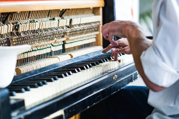 Street musician playing the old shabby piano. — Stock Photo, Image