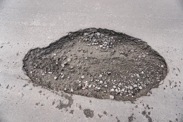 Große Grube mit Steinen auf der Asphaltstraße — Stockfoto