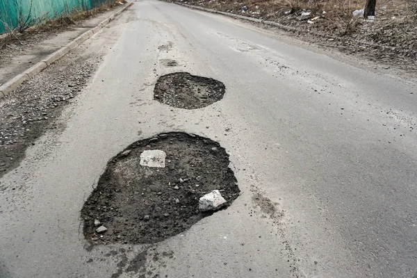 Große Grube mit Steinen auf der Asphaltstraße — Stockfoto