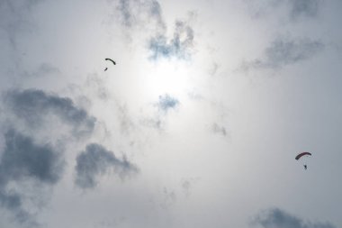 Gün batımından önce uçan bir paraşütçünün silueti.