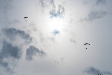 Gün batımından önce uçan bir paraşütçünün silueti.