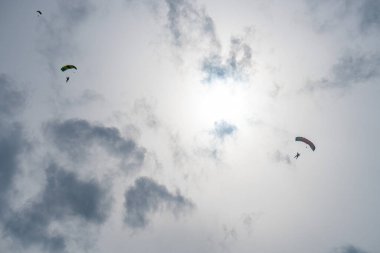 Gün batımından önce uçan bir paraşütçünün silueti.