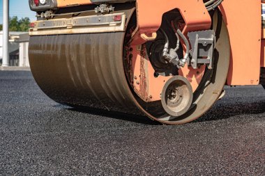 Buharlı silindir, asfalt katranı düzleştirmiş.