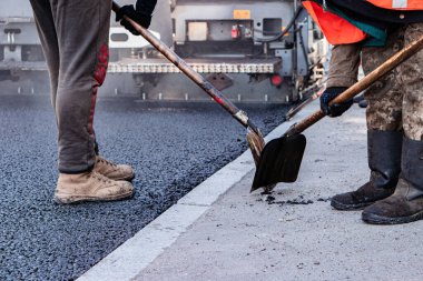 İşçiler yeni asfalt döşemek için eski kaldırımı kaldırıyorlar. Yol onarımı