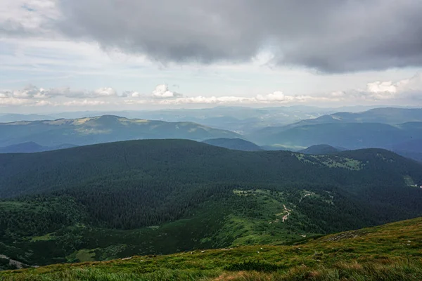 Carpatian yaz manzarası. Mavi gökyüzü arka planında orman olan dağ yolu.