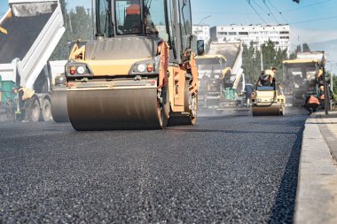 Buharlı silindir, asfalt katranı düzleştirmiş.