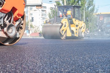 Buharlı silindir, asfalt katranı düzleştirmiş.