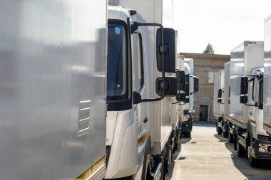 Beyaz kamyonlar ön tarafta duruyor.