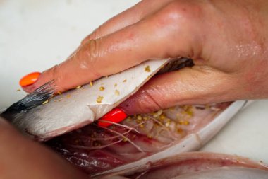 Mutfaktaki masada lezzetli uskumru balığı hazırlayan kadın.