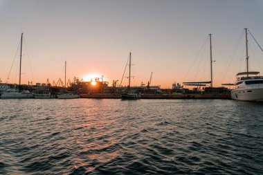 Endüstriyel Karadeniz limanı Odesa, Ukrayna Güzel turuncu günbatımında bir sürü vinç, kulübe, kutu ve tanklarla