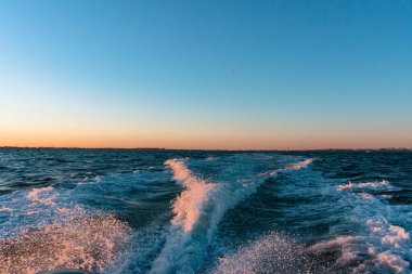 Altın gün batımı ışığında mavi su, yazıtlar için arka plan