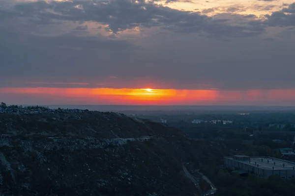 前景のゴミ山背景の日の出 — ストック写真