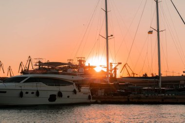 Endüstriyel Karadeniz limanı Odesa, Ukrayna Güzel turuncu günbatımında bir sürü vinç, kulübe, kutu ve tanklarla
