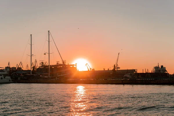 産業用黒海のポートOdesa 多くのクレーンとウクライナ キャビン 美しいオレンジ色の夕日のボックスとタンク — ストック写真