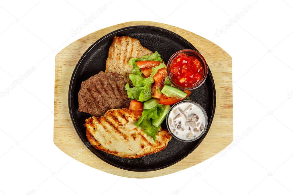 Three meat steaks with sauce on pan, isolated white