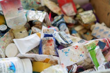 Ressam donatımı yağ renkleri dağınık çalışma alanında yatıyor