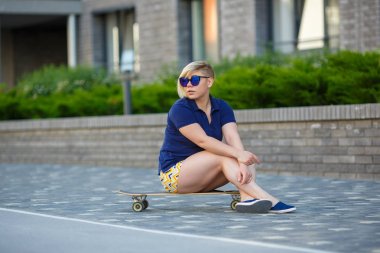 stylish girl plus size sitting on a longboard