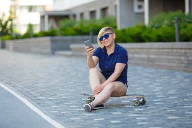 stylish girl plus size sitting on a longboard