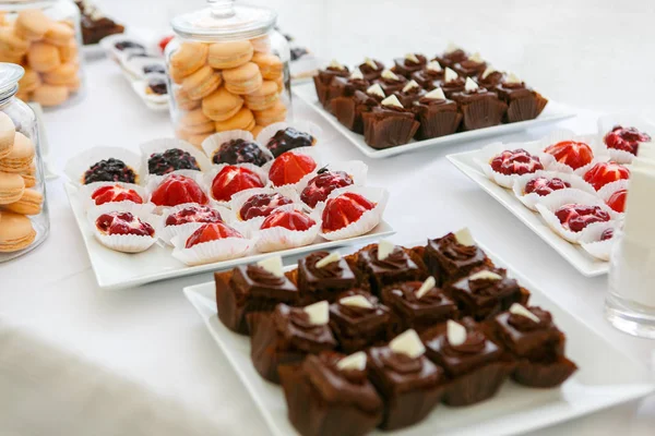 Una mesa se sirve con platos blancos con dulces — Foto de Stock