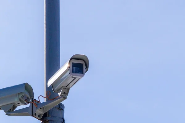 Duas câmaras de segurança contra o céu azul estão a monitorizar . — Fotografia de Stock