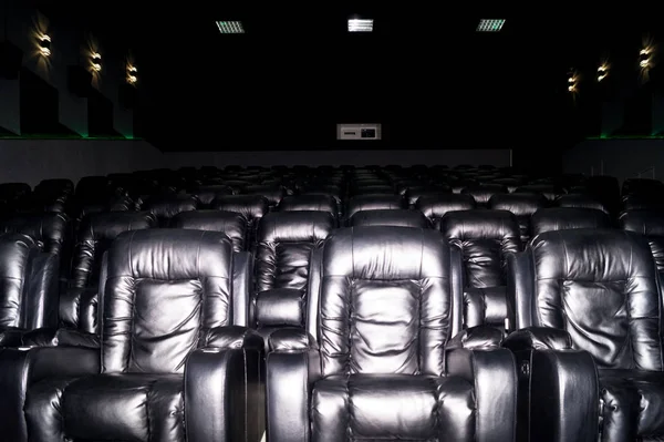 The interior of a cinema hall with black leather seats. The film — Stock Photo, Image