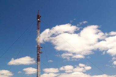 Mavi gökyüzünün arka planında antenler olan yüksek radyo televizyon kulesi. Kentsel iletişim teknolojisi.