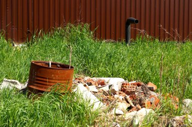 Şehirdeki yeşil çimenlerin üzerine yığılmış bir çöp yığını. Kentsel ekoloji.