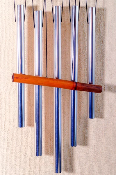 Metal tubular bells with a bamboo tube hang on the wall and create the music of the wind. Musical instrument.