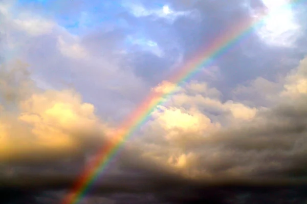雨后多云的天空上美丽的彩虹 免版税图库图片