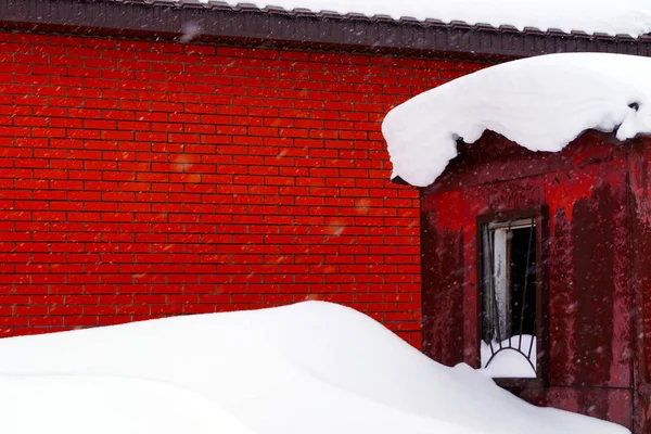 住宅の建物にはたくさんの雪が積もっていて 周りには大きな雪が降っています — ストック写真