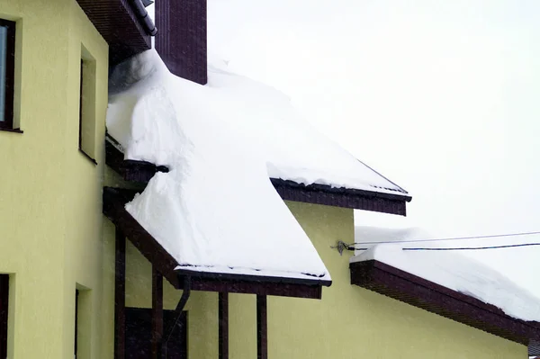 住宅の建物にはたくさんの雪が積もっていて 周りには大きな雪が降っています — ストック写真