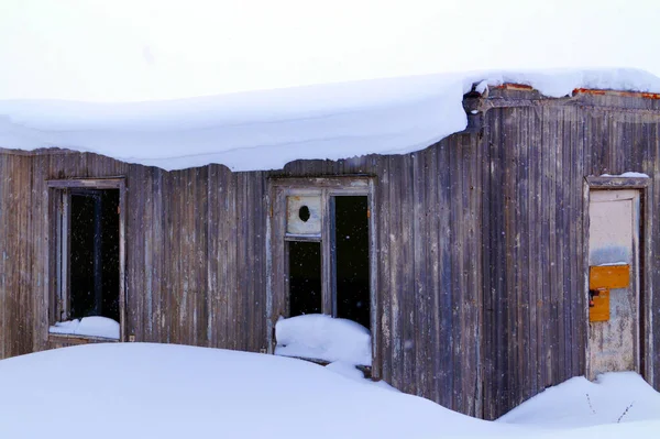 住宅の建物にはたくさんの雪が積もっていて 周りには大きな雪が降っています — ストック写真