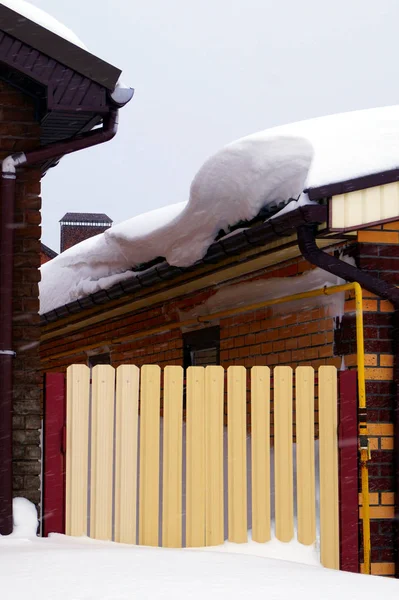 住宅の建物にはたくさんの雪が積もっていて 周りには大きな雪が降っています — ストック写真