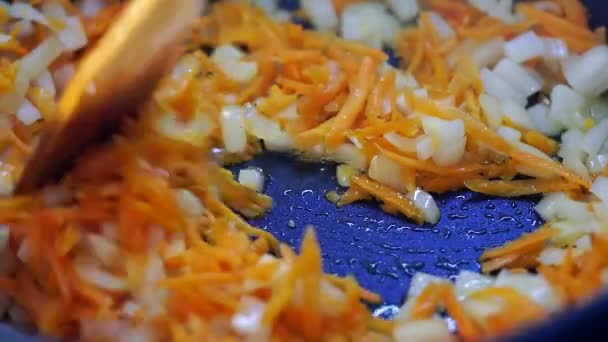 Gebakken groenten in een pan wortelen en uien close-up — Stockvideo