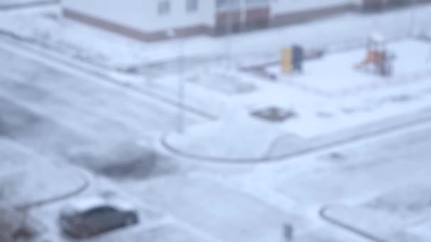 Летящий снег на фоне зимнего города — стоковое видео