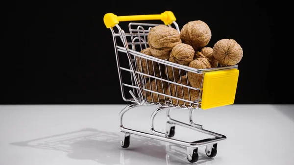 Conceptwinkel wagen met walnoten op witte achtergrond, dieetvoeding. — Stockfoto